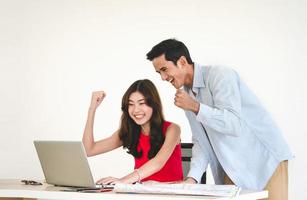 Young adult southeast asian couple using laptop getting ready for honeymoon travel trip photo