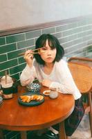 Portrait of young adult asian woman with 80s style japanese fashion in retro chinese cafe photo