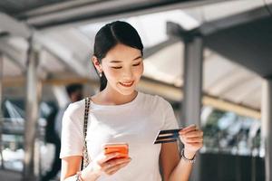 Young adult business asian woman consumer using creadit card and smartphone for shopping online. photo