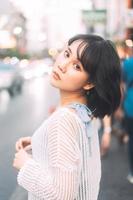 retrato de una joven asiática adulta con moda japonesa al estilo de los años 80 en la ciudad al aire libre foto