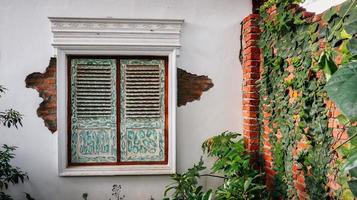 Green home building with old window photo