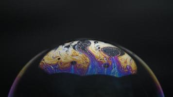 Soap bubbles isolated on black background. Abstract soap bubbles with colorful reflections. Soap bubbles in motion background. video