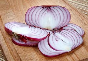 Onion and ripe juicy onion cut into rings on a wooden board. photo