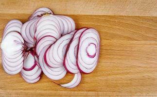 A juicy onion cut into rings on a wooden board. photo