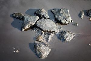 piedras negras en un charco de agua. foto