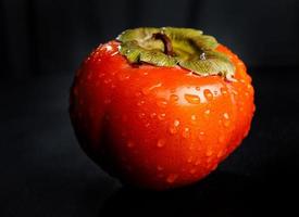 Drops of water on the peel of juicy persimmon. photo