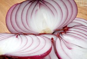 Cut juicy onions on a wooden board close-up. photo