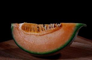 Slice of juicy melon on a wooden board. photo