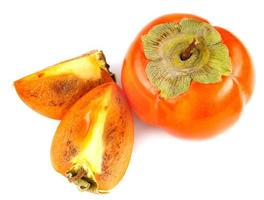 Ripe persimmon and two slices of persimmon are isolated on a white background. top view. photo