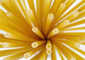 Long tubular pasta diverge with a fan from one point, a top view. photo