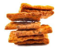 A stack of crispy breads with coarse salt and spices is isolated on a white background. photo