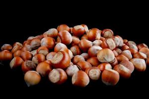 Hazelnut slide. Solid ripe hazelnuts on a black background. photo