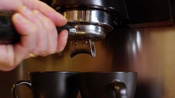 Waitress pluging a tamper to barista coffee machine. video