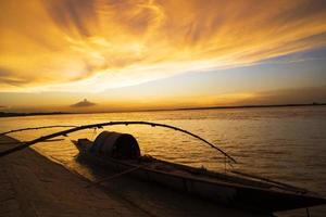 un barco de madera en el mar contra el cielo durante la puesta de sol foto