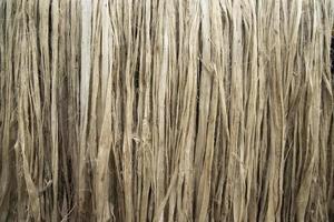 Closeup shot of raw jute fiber hanging under the sunlight for drying. Brown jute fiber texture and  background photo
