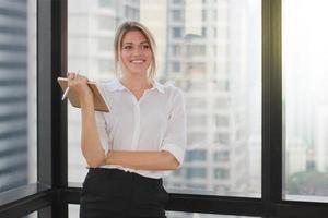 Portrait of a businesswoman holding notebook in modern office photo