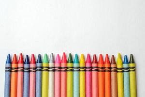 Multicolored crayons lined up on white background. photo