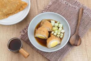 Pempek, Empek-Empek, traditional food from South Sumatra, Indonesia. This fish-based food is very popular. Served with cuko sauce and cucumber slices. photo