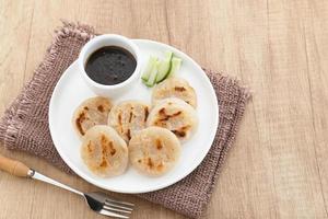 Pempek Panggang or Pempek Tunu, traditional food from South Sumatra, Indonesia. This fish-based food is very popular. Served with cuko sauce. photo