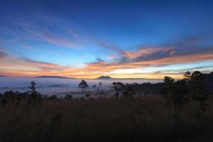 Misty morning sunrise at Thung Salang Luang National Park Phetchabun,Tung slang luang is Grassland savannah in Thailand photo