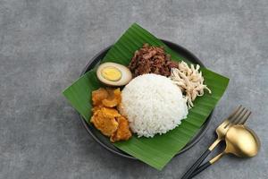 Gudeg, a typical food from Yogyakarta, Indonesia, made from young jackfruit cooked with coconut milk. Served with spicy stew of cattle skin crackers, brown eggs, shredded chicken and sambal. photo