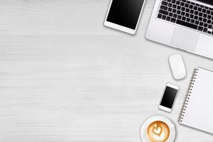 Modern workspace with laptop tablet, smartphone and coffee cup copy space on wood background. Top view. Flat lay style. photo