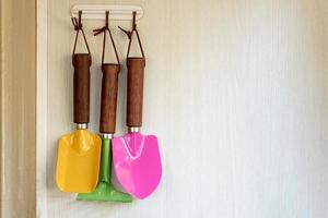 Gardener colored tools hold on wall photo