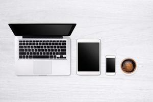 Laptop tablet smartphone  and coffee on wood table background with text space and copy space photo