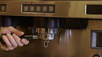 Waitress pluging a tamper to barista coffee machine. video