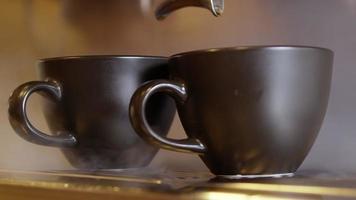 caffè espresso versando dalla macchina per caffè espresso. fare il caffè fresco uscendo da una macchinetta del caffè. avvicinamento. scatto professionale con risoluzione 4k. video