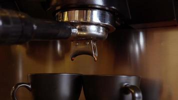 espresso koffie gieten van espressomachine. het maken van verse koffie uit een koffiezetapparaat. detailopname. professionele opname in 4k-resolutie. video
