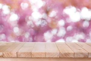 brown wood table top on bokeh abstract pink background - can be used for montage or display your products photo