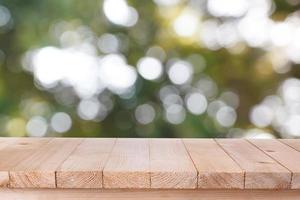 brown wood table top on bokeh abstract green background - can be used for montage or display your products photo