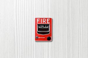 interruptor de alarma contra incendios sobre fondo de madera blanca foto