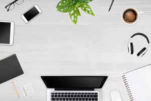 Modern workspace with laptop tablet, smartphone and coffee cup copy space on color background. Top view. Flat lay style. photo