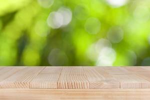 Wood table top on natural green bokeh background- can be used for montage or display your products photo