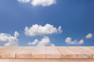 brown wood table top on bokeh abstract blue sky background - can be used for montage or display your products photo