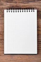 Blank empty notepad on wood background photo