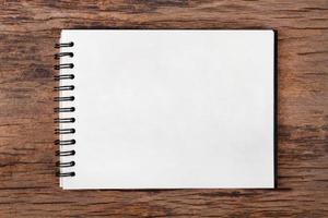 Blank empty notepad on wood background photo