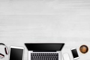 Modern workspace with laptop tablet, smartphone and coffee cup copy space on wood background. Top view. Flat lay style. photo