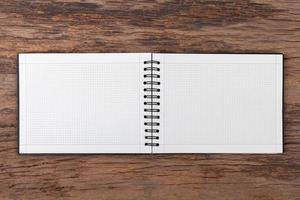 Blank empty notepad on wood background photo