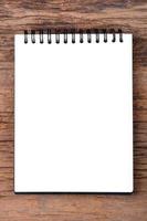 Blank empty notepad on wood background photo