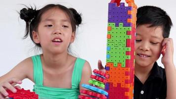 asiatische kinder spielen ein kreatives spiel aus puzzle-plastikblöcken, um ihre körperlichen und geistigen fähigkeiten zu üben video