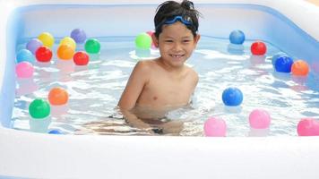 7 years boy playing in small swimming pool toy video