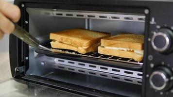 señora cocinera desayuno sándwich en un pequeño horno de cocina casera - concepto de cocina casera video