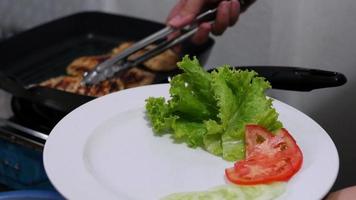 as pessoas fazem bife de frango na cozinha com vegetais verdes - conceito de preparação de comida caseira video