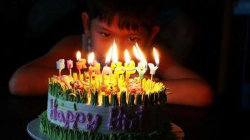 il bambino soffia felicemente le candeline sulla sua torta di compleanno video