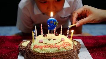 il bambino sta tagliando felicemente la torta nella sua festa di compleanno - concetto di celebrazione della festa di compleanno felice e gioiosa