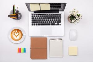 Top view laptop or notebook workspace office and latte coffee on white table photo