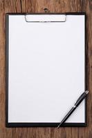 white blank paper on clipboard with space on wood background